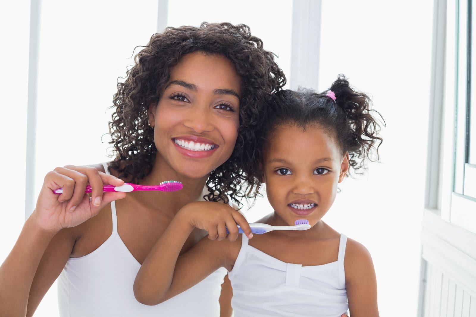 Mother and daughter brushing their teeth together family hygiene